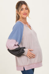 woman wearing a multicolor striped maternity top with a relaxed fit and a visible baby bump
