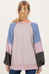 woman wearing a multicolored long sleeve maternity top with balloon sleeves and a relaxed fit, showing back view