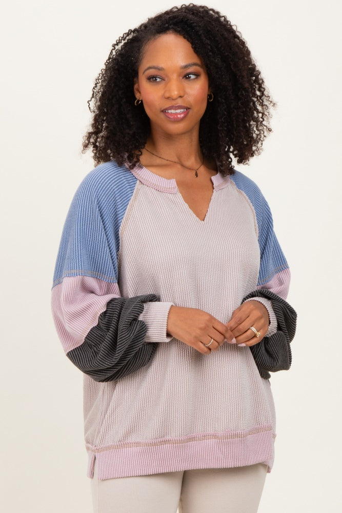 woman wearing a pastel color block long sleeve top with a v-neck and raglan sleeves