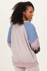 woman wearing a multicolored oversized striped sweater with a relaxed fit and raglan sleeves