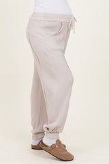 woman wearing light pink maternity joggers with a drawstring waist and pockets