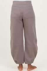 woman wearing light gray maternity sweatpants with elastic cuffs and side pockets, seen from the back