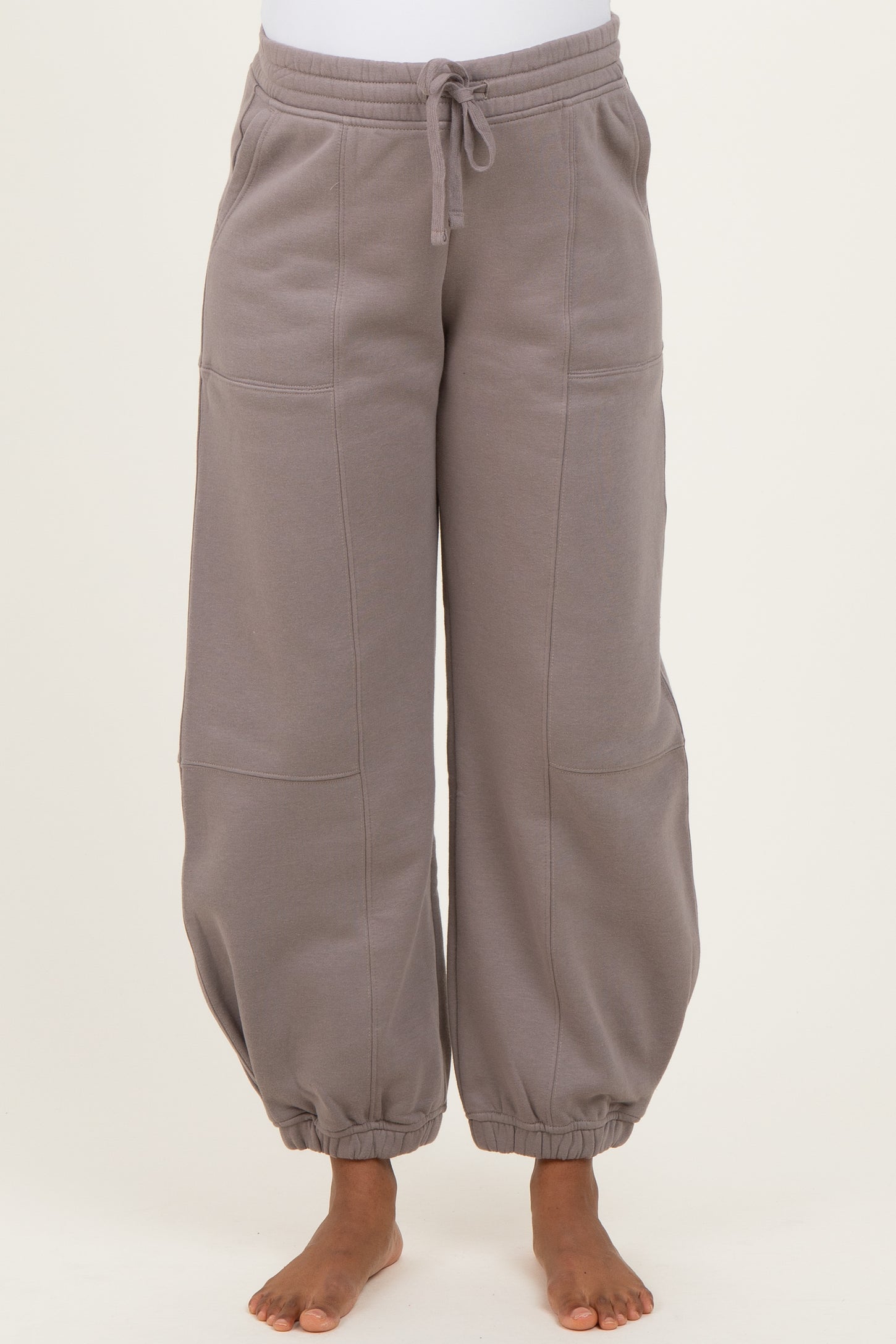 woman wearing gray maternity jogger pants with a drawstring waist and elastic cuffs