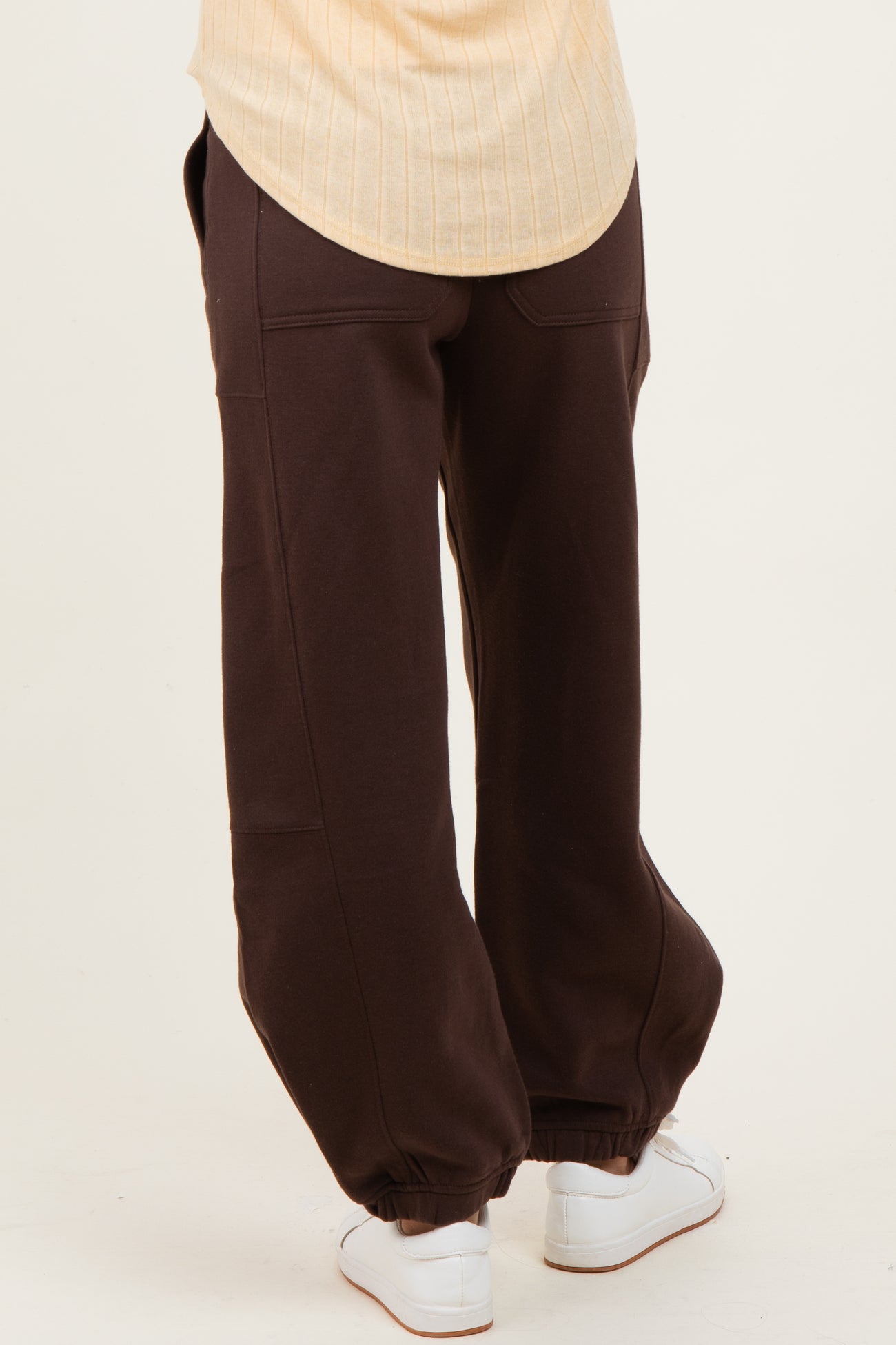 woman wearing brown maternity sweatpants with tapered cuffs and a relaxed fit
