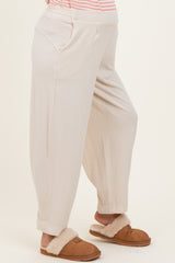 woman wearing beige maternity jogger pants with pockets, styled with soft slippers