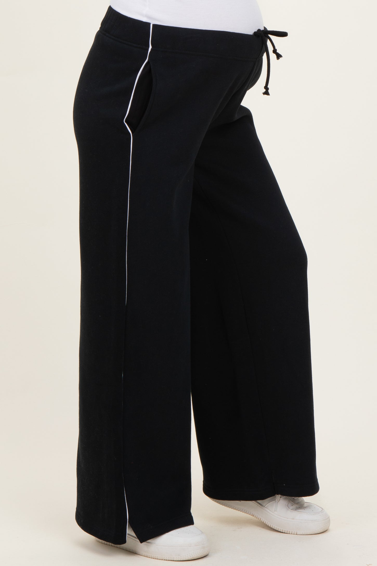 woman wearing black maternity sweatpants with white side stripes and drawstring waist