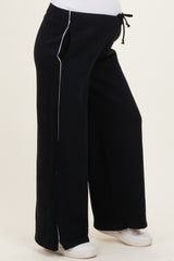 woman wearing black maternity sweatpants with white side stripes and drawstring waist