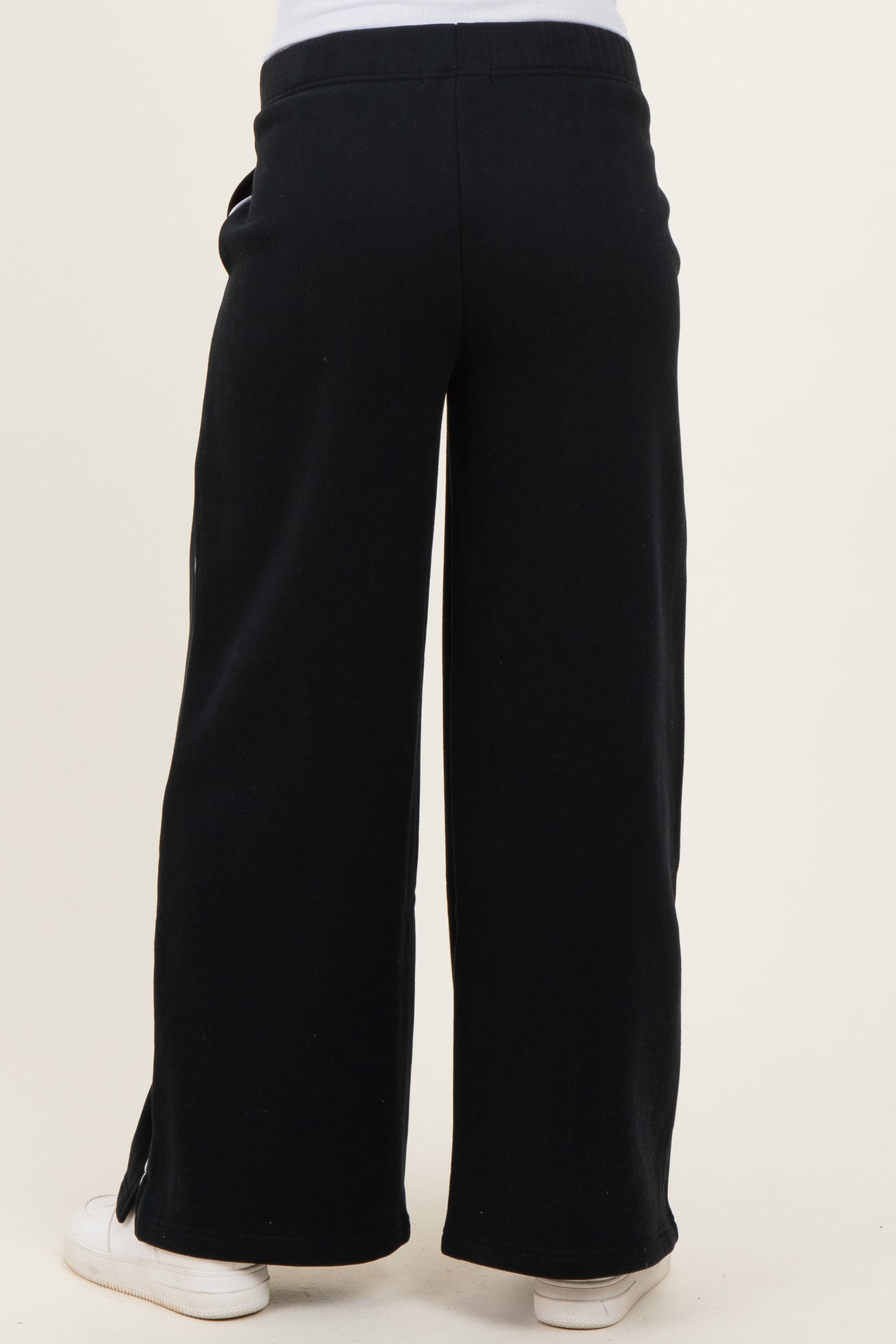 woman wearing black wide-leg maternity pants with a relaxed fit, showing the back view