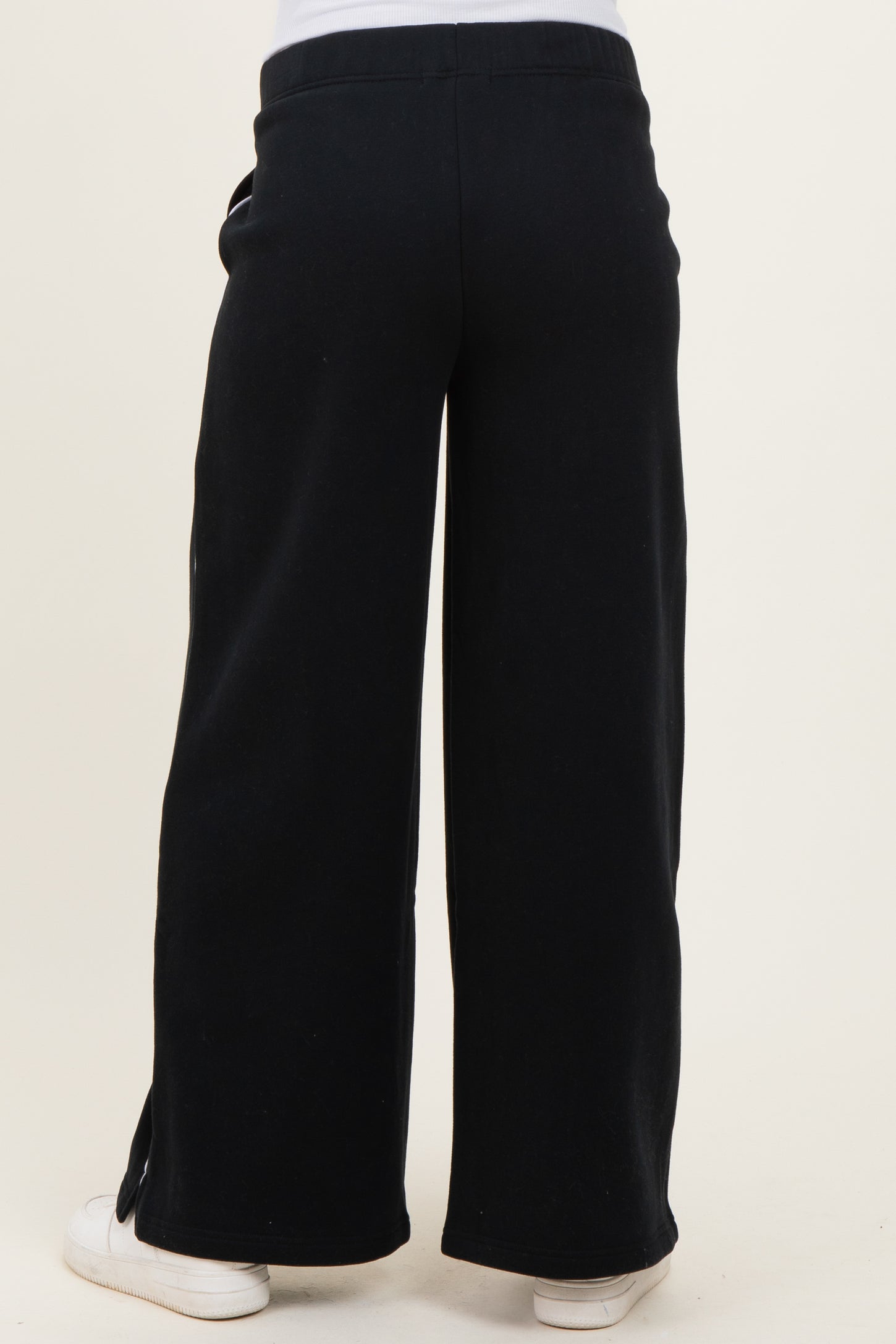 woman wearing black wide-leg maternity pants with a relaxed fit, showing the back view
