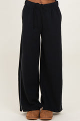 woman wearing navy blue wide-leg lounge pants with an elastic waistband and side pockets