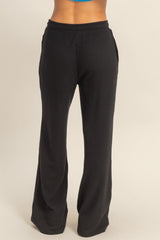 woman wearing black ribbed wide-leg pants featuring side pockets and an elastic waistband