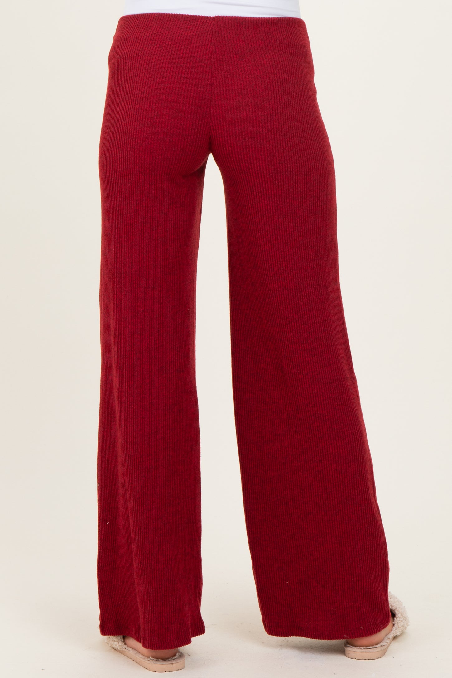 woman wearing red ribbed maternity pants with a wide-leg style, shown from the back