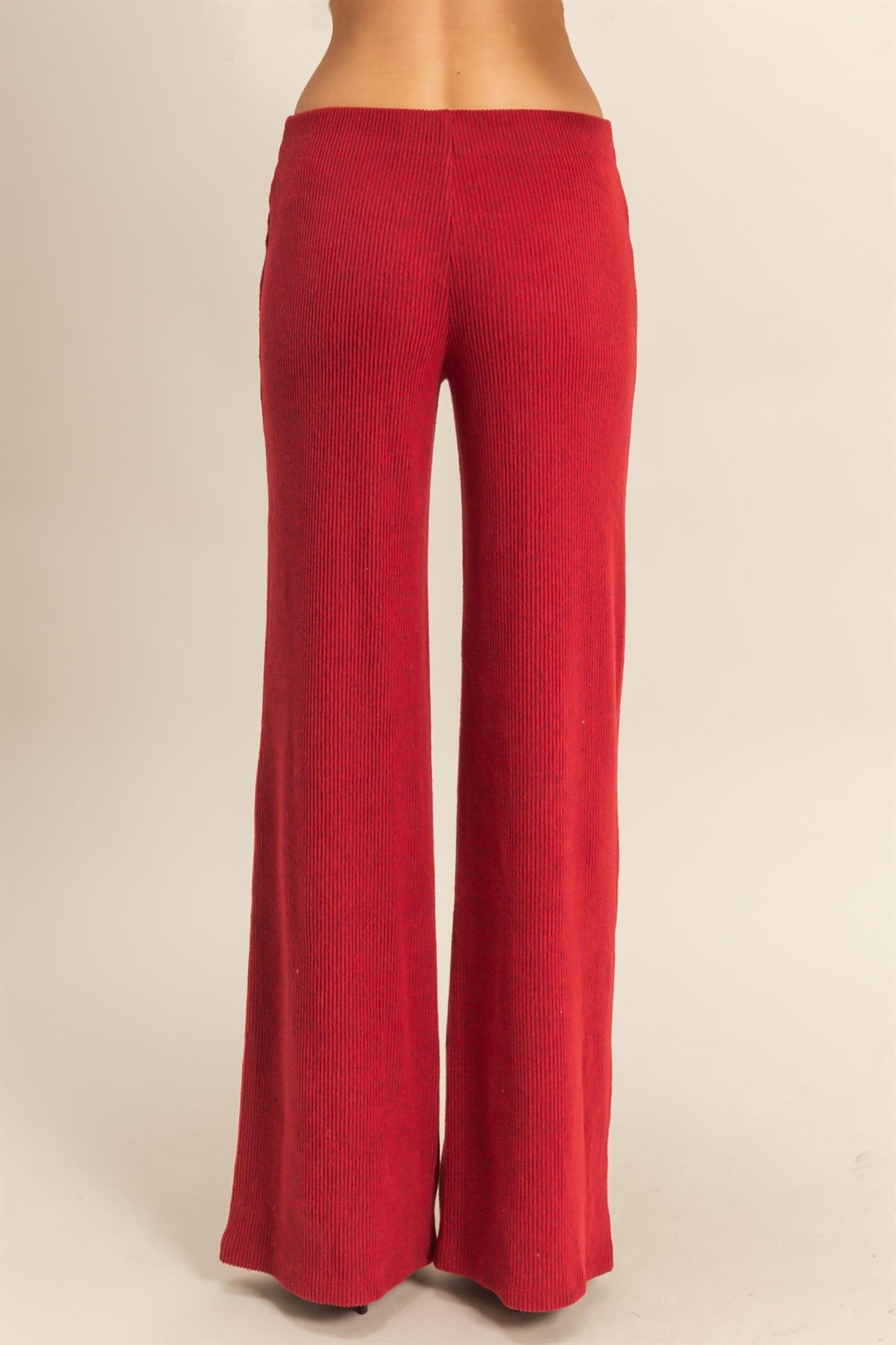 woman wearing high-waisted red ribbed wide-leg pants seen from the back