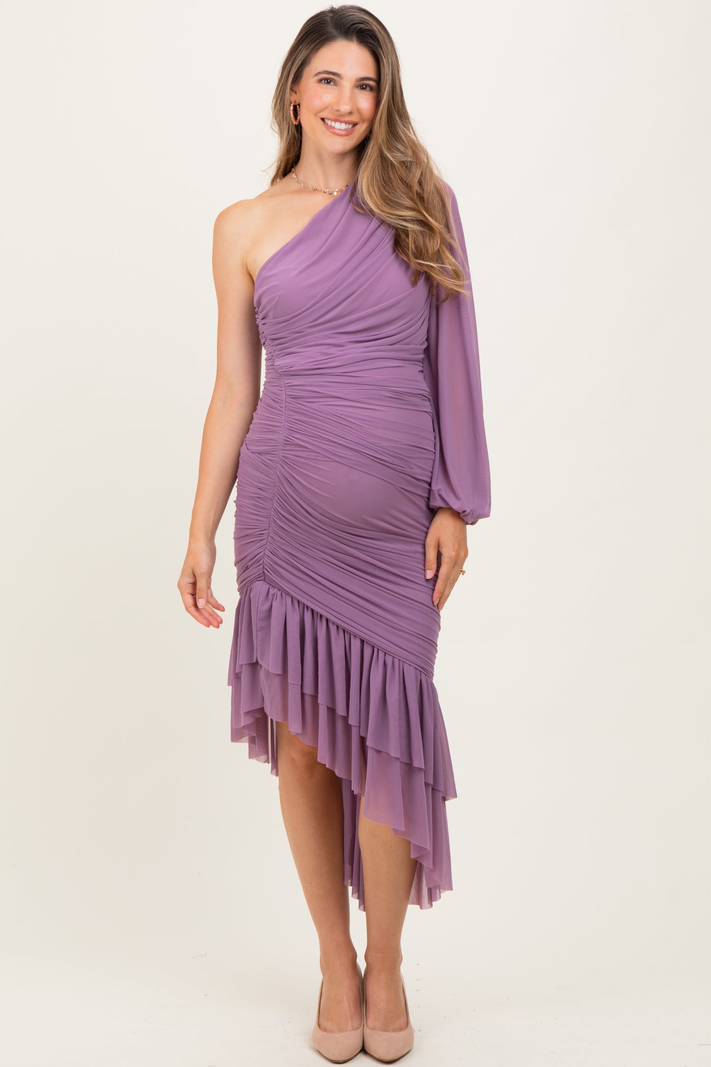 woman wearing a lavender one-shoulder maternity dress with ruching and a layered skirt design