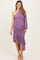 woman wearing a lavender one-shoulder maternity dress with ruching and a layered skirt design