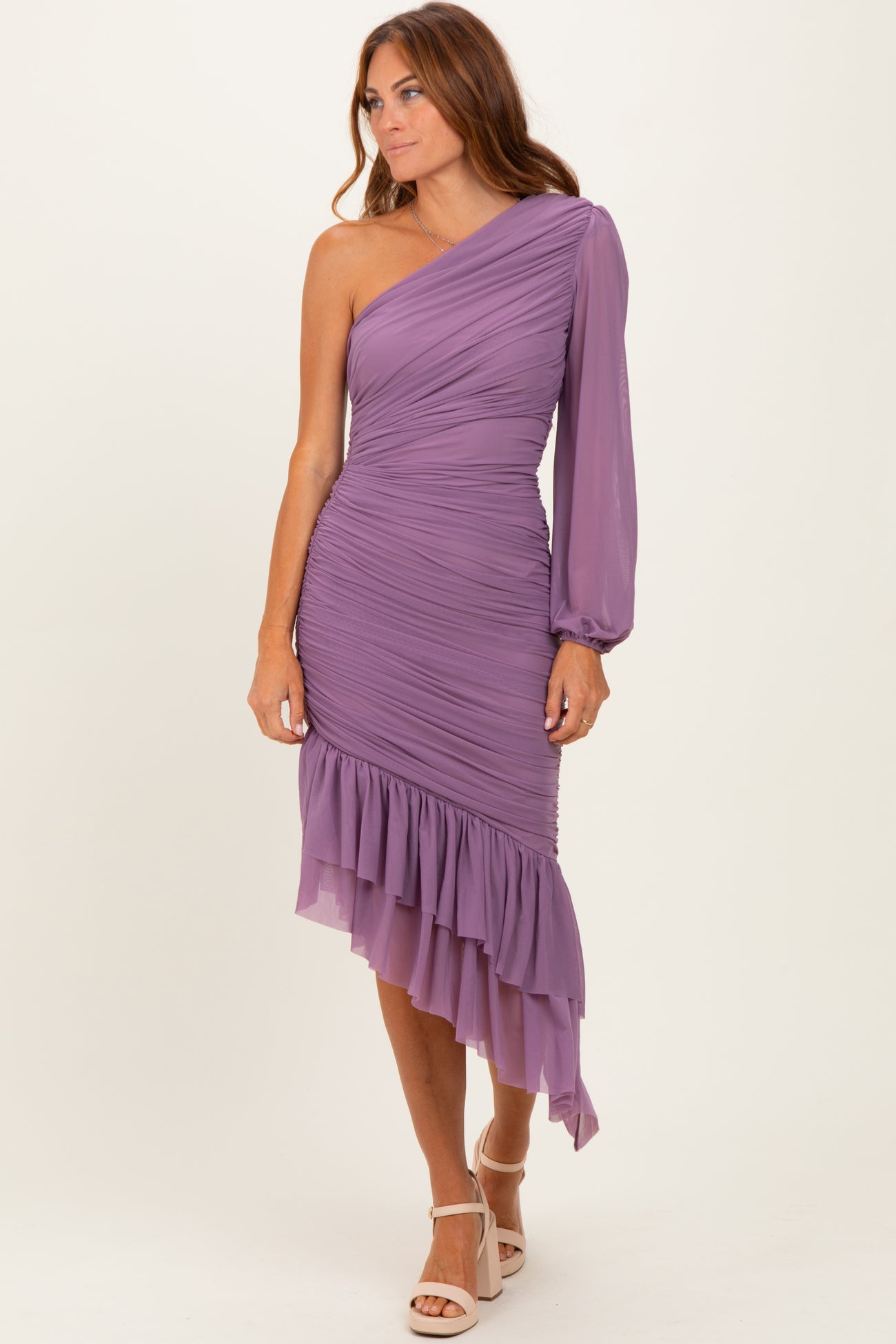 woman wearing a one-shoulder purple ruched dress with a ruffled asymmetrical hem and long puff sleeve