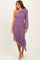 woman wearing a one-shoulder purple ruched dress with a ruffled asymmetrical hem and long puff sleeve