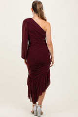 woman wearing a burgundy one-shoulder maternity dress with ruching and a ruffled hem, viewed from the back