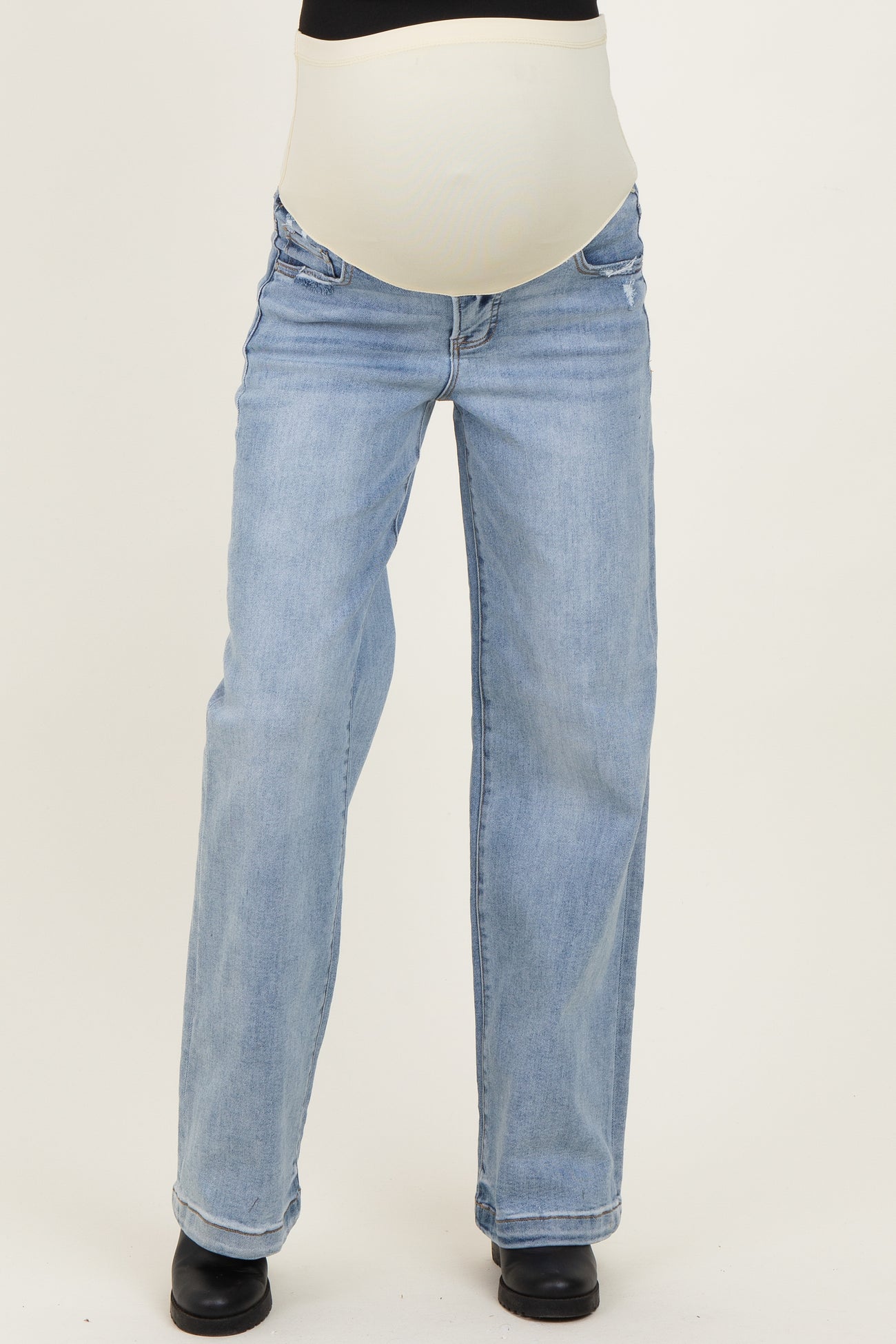woman wearing light blue maternity jeans with a supportive belly band