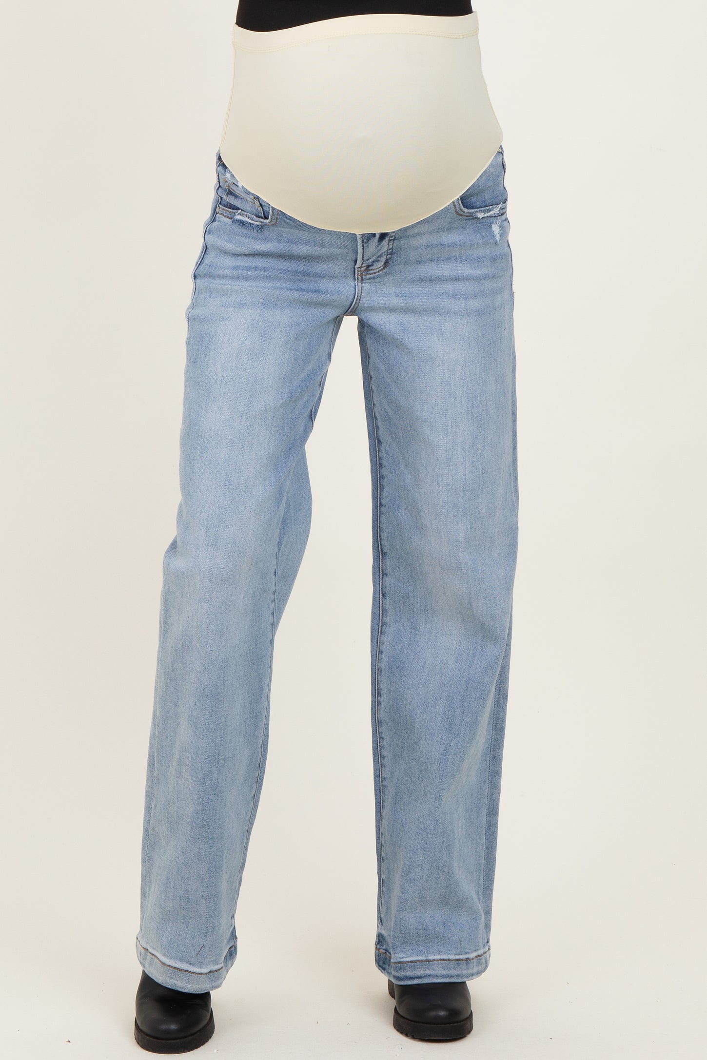 woman wearing light blue maternity jeans with a supportive belly band