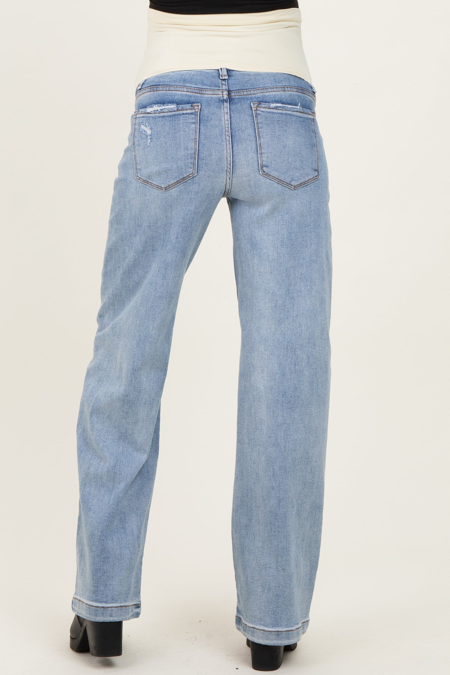 woman wearing light blue maternity jeans with a wide leg and elastic waistband, showing the back view