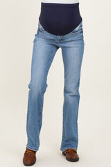 woman wearing light blue bootcut maternity jeans with a navy blue over-the-belly waistband