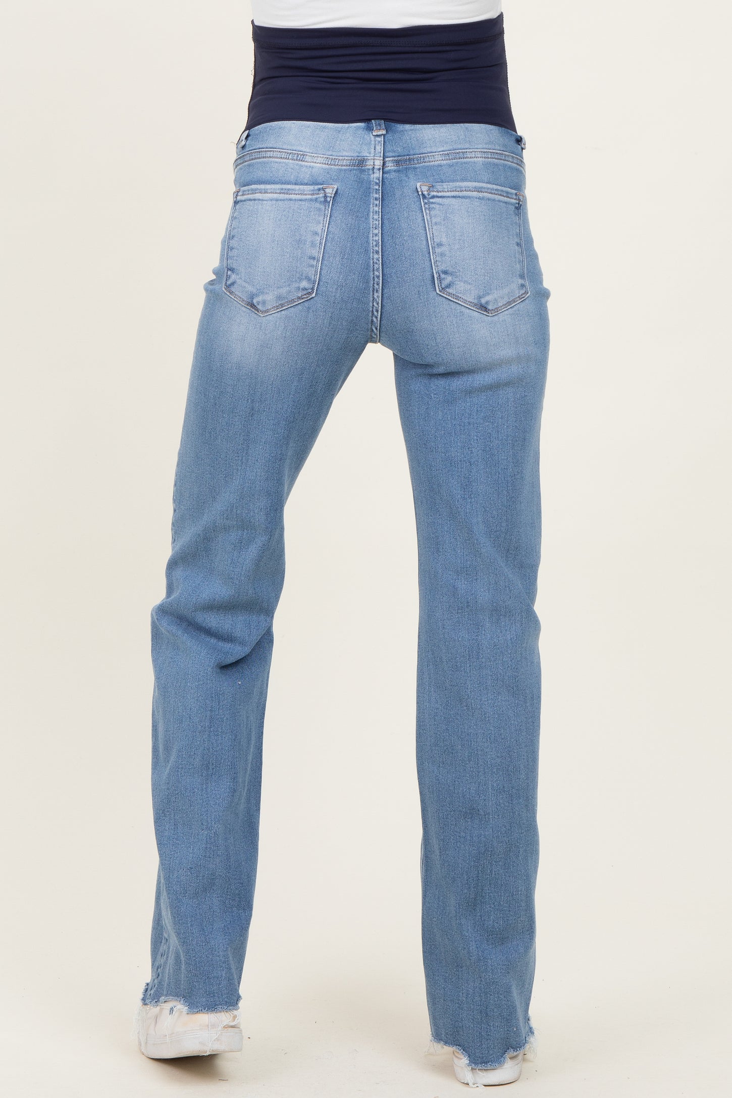 woman wearing light blue maternity jeans with a stretchy waistband, viewed from the back