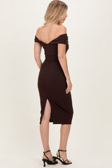 woman wearing a burgundy off-the-shoulder midi dress with a slit and strappy black heels, viewed from the back