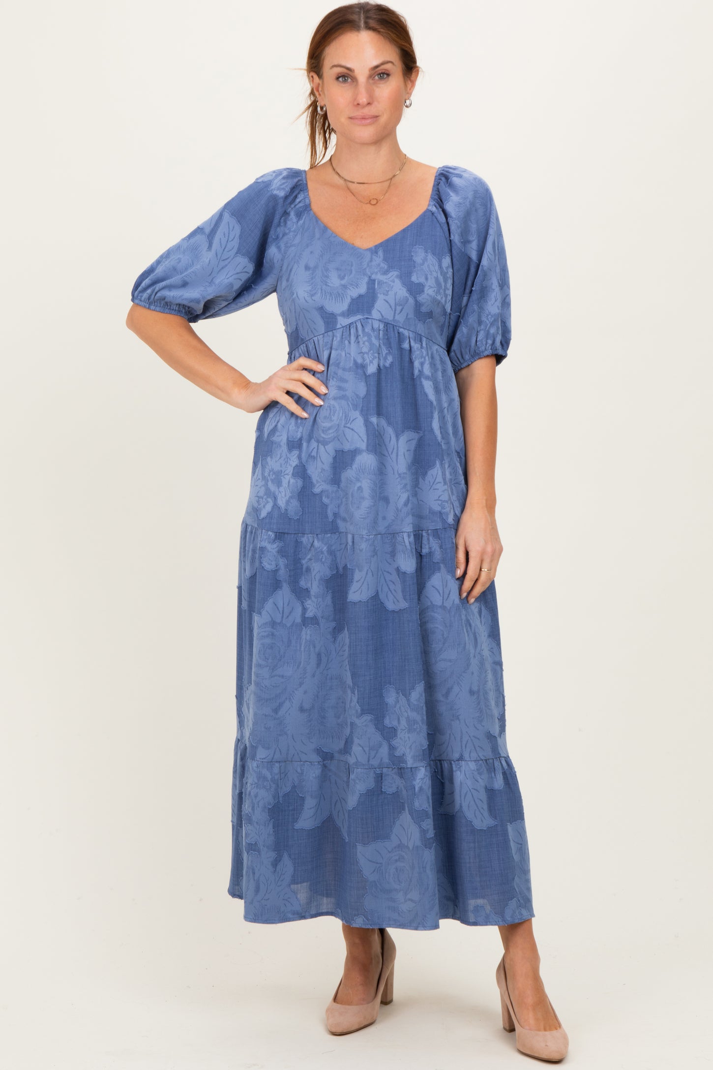 woman wearing a blue floral maxi dress with puff sleeves and a tiered skirt