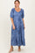 woman wearing a blue floral maxi dress with puff sleeves and a tiered skirt, styled with nude heels