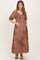 woman wearing a brown floral maternity maxi dress and holding her baby bump
