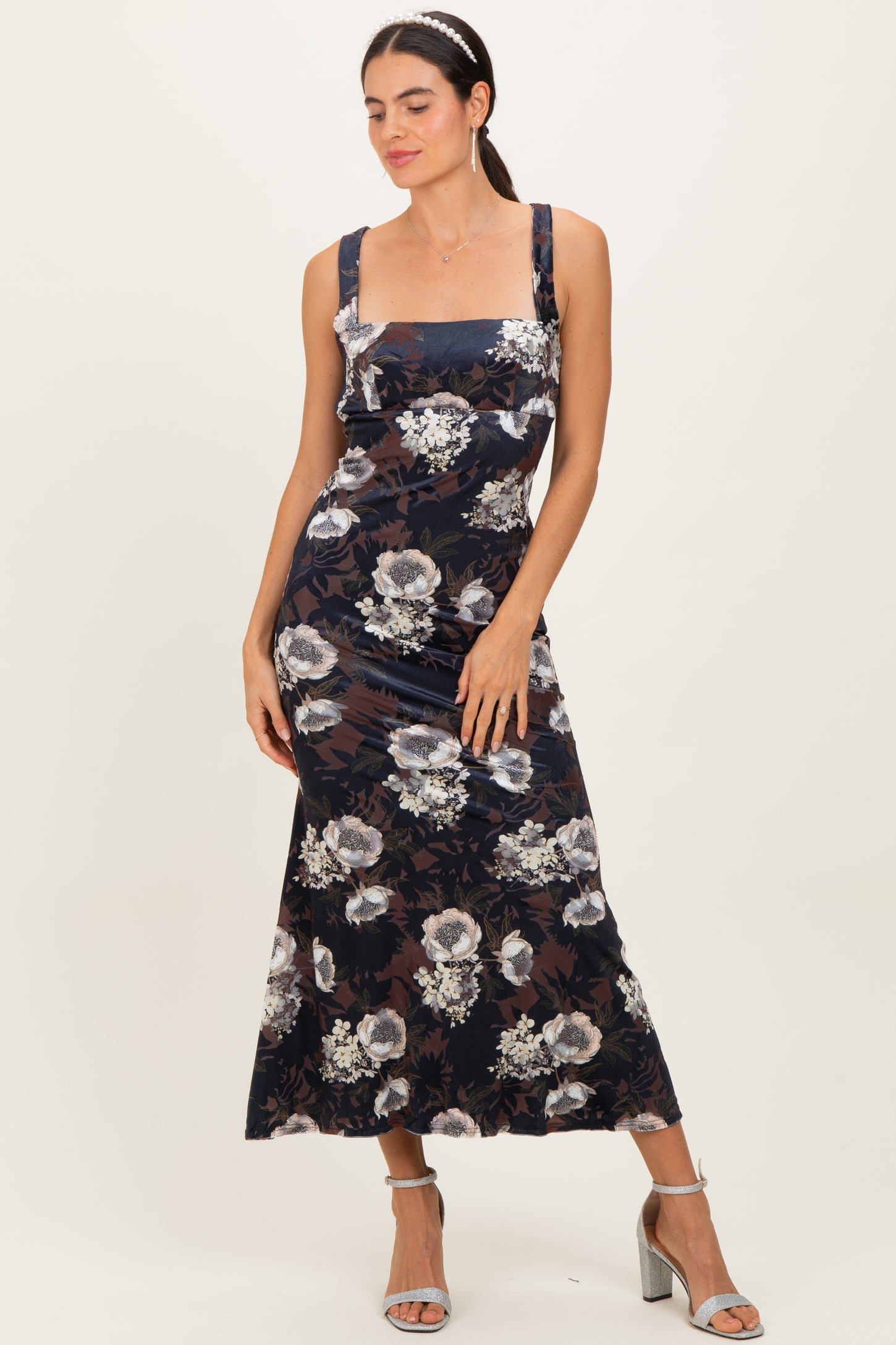 woman wearing a navy floral maxi dress with square neckline and wide straps