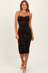 woman wearing a black and orange ruched bodycon midi dress with thin straps and a sweetheart neckline
