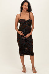 woman wearing a black and copper ruched maternity dress, highlighting her baby bump, standing and smiling