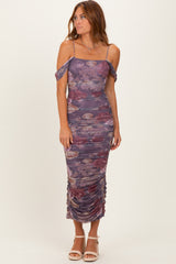 woman wearing a purple floral ruched midi dress with off-shoulder straps and side slits
