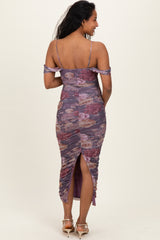 woman wearing a purple floral off-shoulder maternity dress with ruching and a side slit