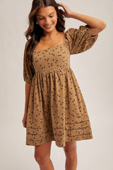 woman wearing a brown floral print puff sleeve dress with a square neckline and a gathered waist