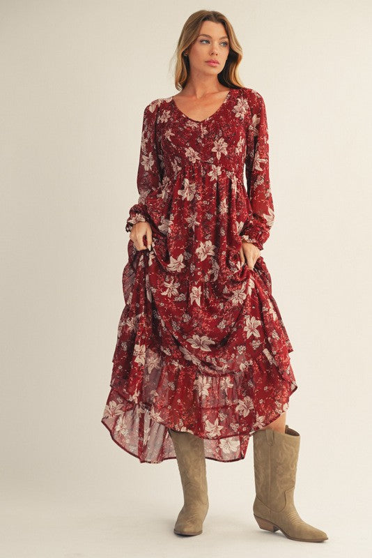 woman wearing a red floral maxi dress with long sleeves and ruffles, paired with beige knee-high boots