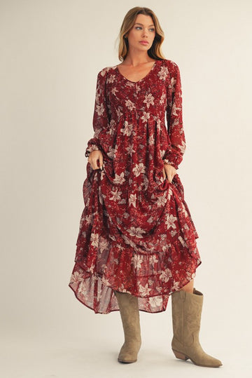 woman wearing a red floral maxi dress with long sleeves and ruffles, paired with beige knee-high boots
