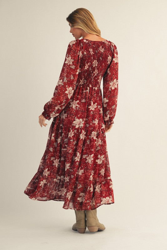 woman wearing a red floral long sleeve maxi dress with a tiered skirt and a flowy silhouette, seen from the back