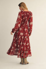 woman wearing a red floral long sleeve maxi dress with a tiered skirt and a flowy silhouette, seen from the back