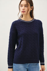 woman wearing a navy blue cable knit sweater with a contrasting collar detail and long sleeves