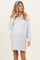 woman wearing a light gray maternity zip-up dress with long sleeves and a relaxed fit, holding her pregnant belly