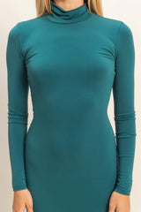 woman wearing a fitted teal long sleeve mock neck dress with form-fitting design
