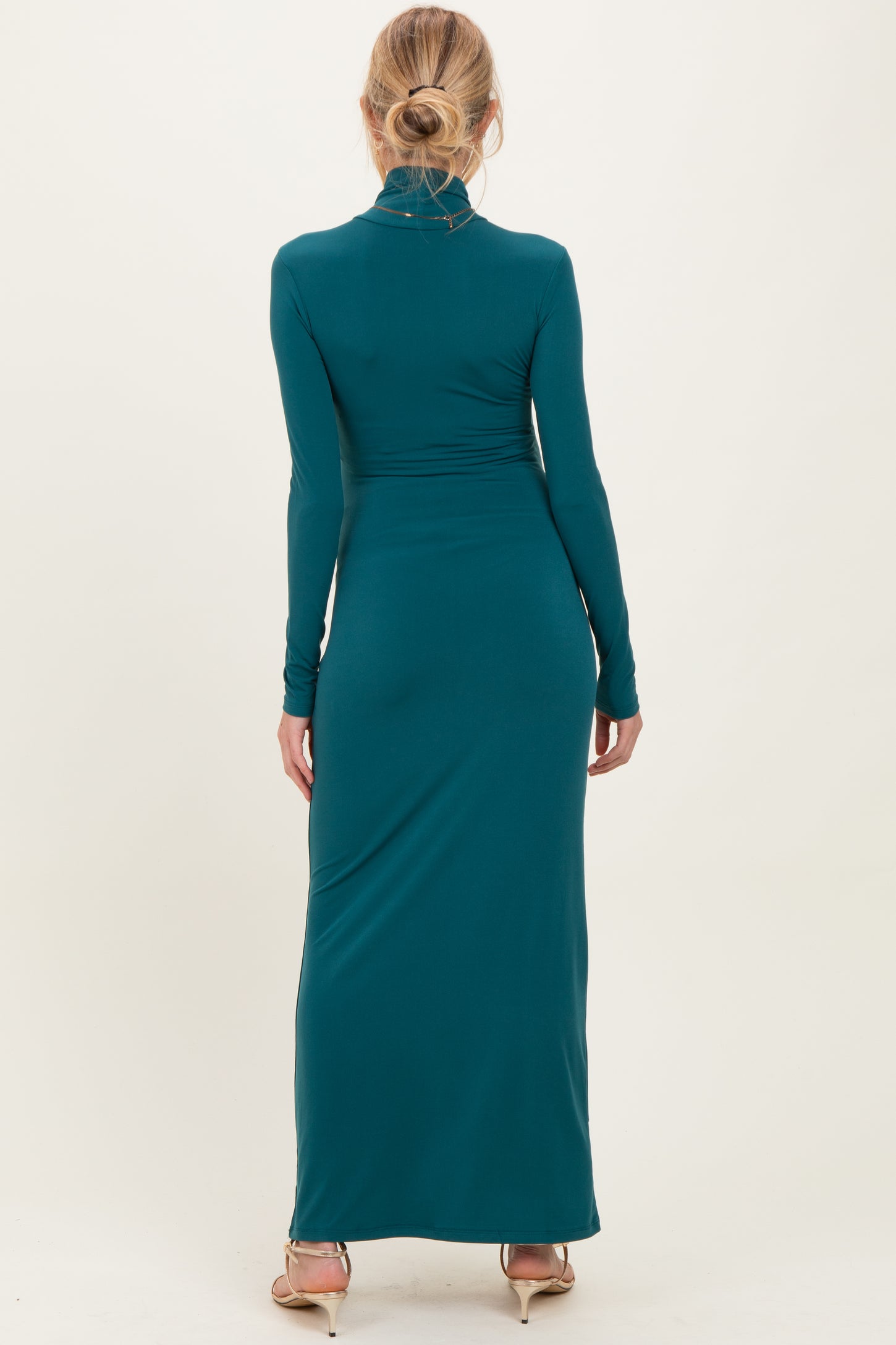 woman wearing a long sleeve teal maternity maxi dress from the back