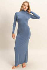 woman wearing a long sleeve blue maxi dress with a high neckline and fitted silhouette