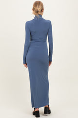 woman wearing a form-fitting maternity maxi dress in a soft blue color, showcasing a sleek long sleeve design from the back
