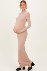 woman wearing a nude long sleeve maternity dress with a fitted silhouette and a visible baby bump