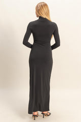 woman wearing a long black fitted dress with long sleeves and a high neckline, seen from the back