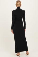 woman wearing a black long sleeve maternity dress with a fitted silhouette and a mock neck